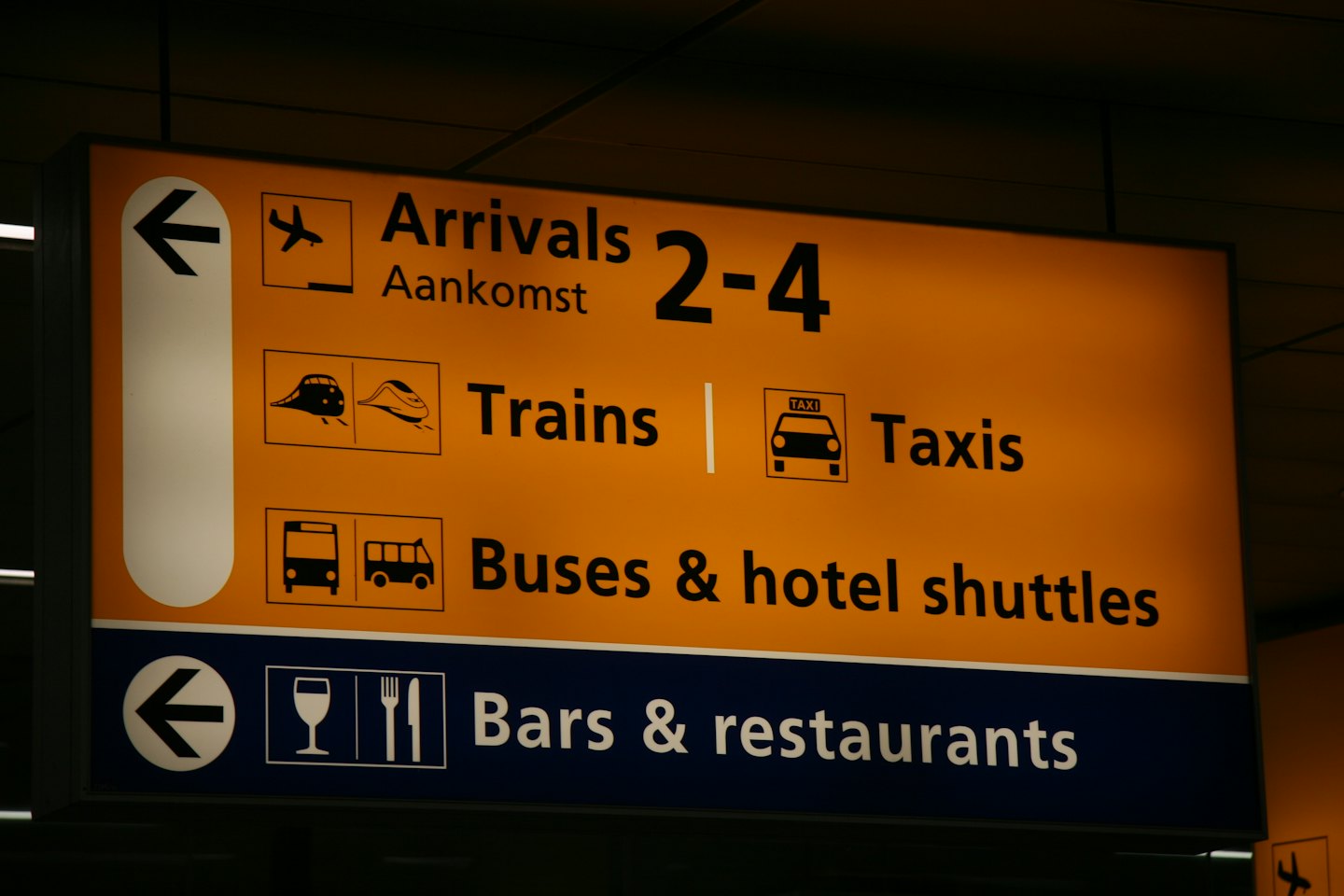 Luchthaveninformatiebord met aanwijzingen naar diverse OV-opties.