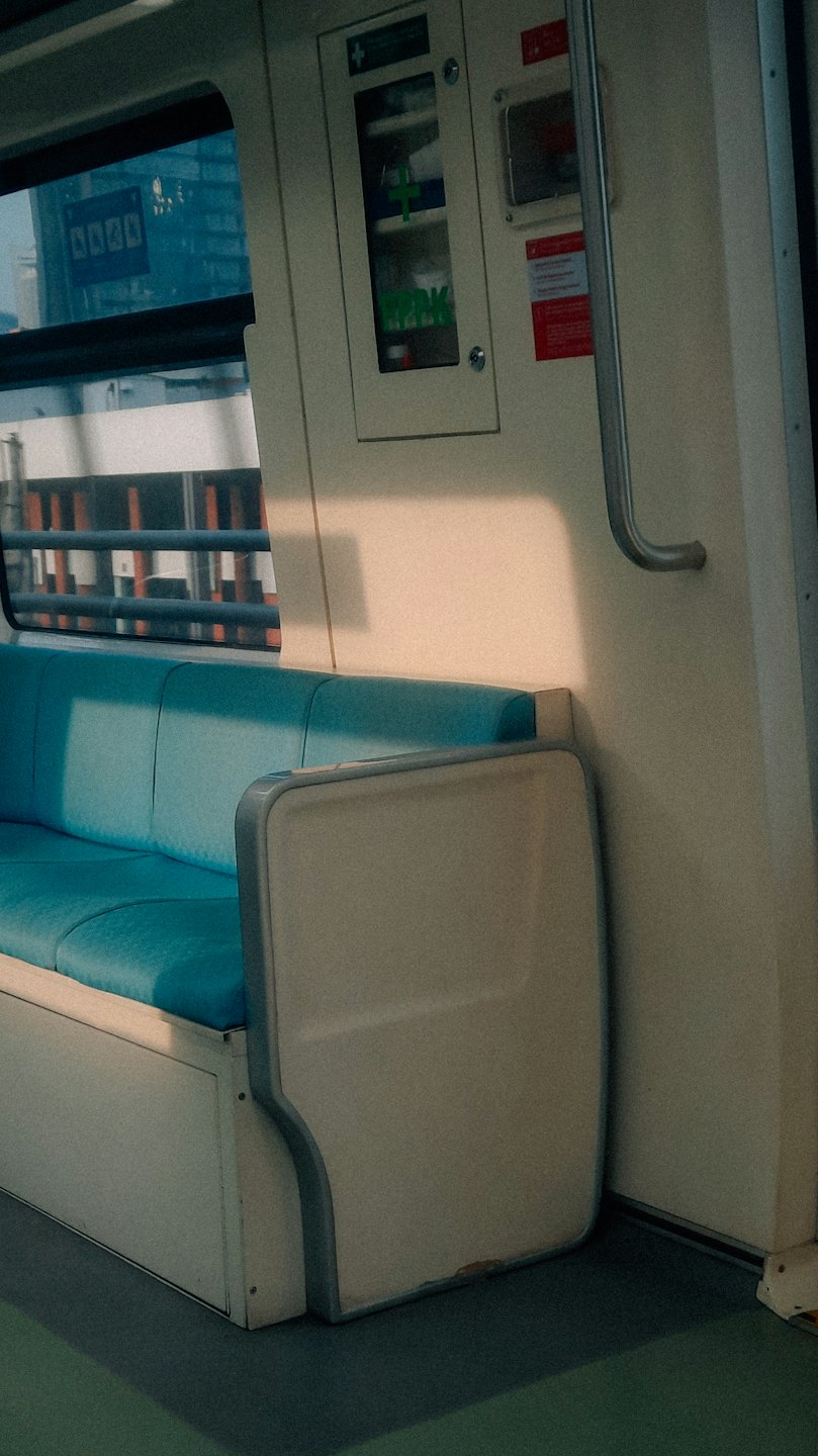 Lege teal stoelen in een fel verlichte openbaar vervoer wagon.